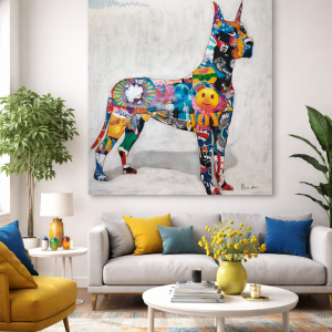 Cuadro decorativo grande de un perro estilo gran danés en perfil, realizado con collage multicolor sobre fondo blanco, colocado como pieza protagonista en un salón moderno.